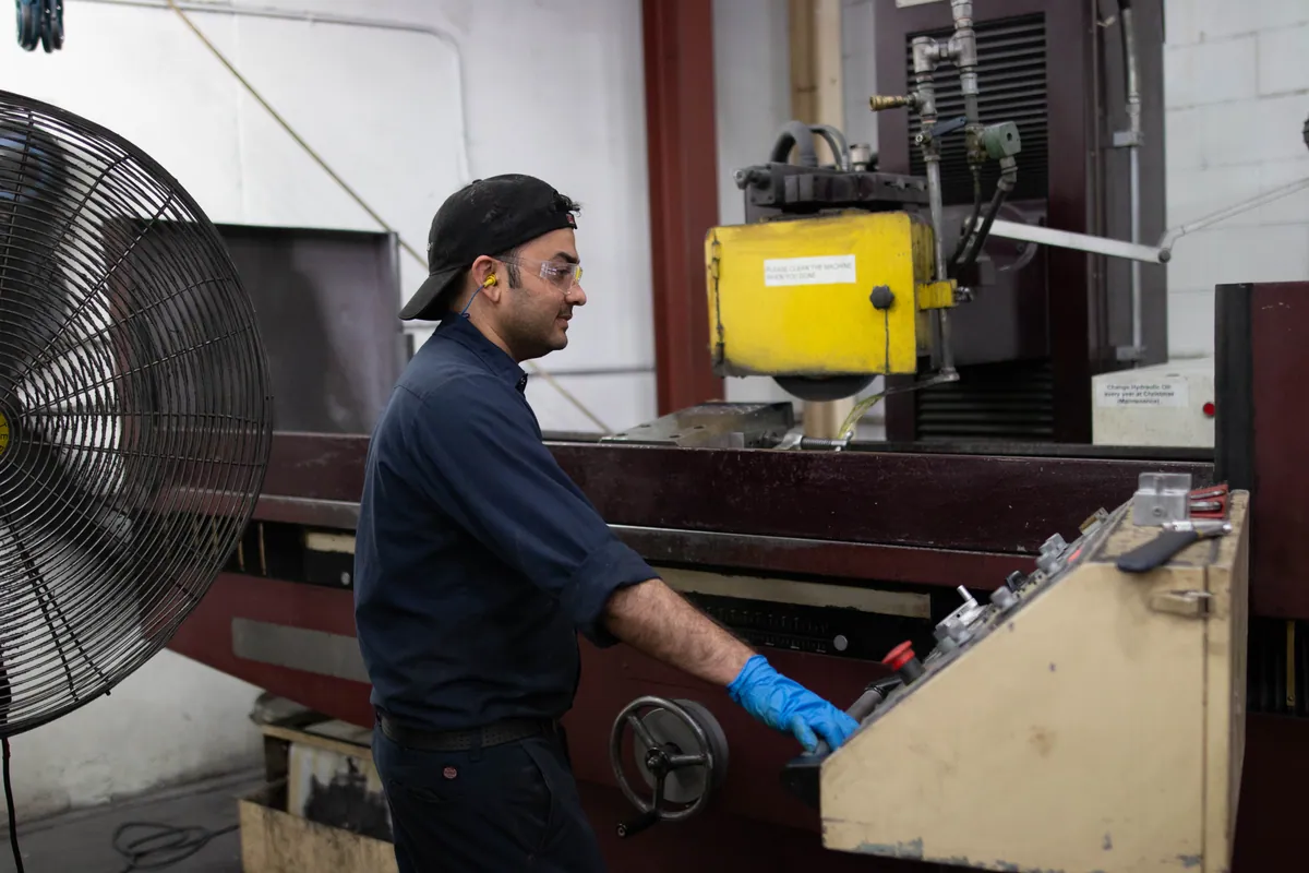 A Clover operator running a finishing machine on the shop floor.
