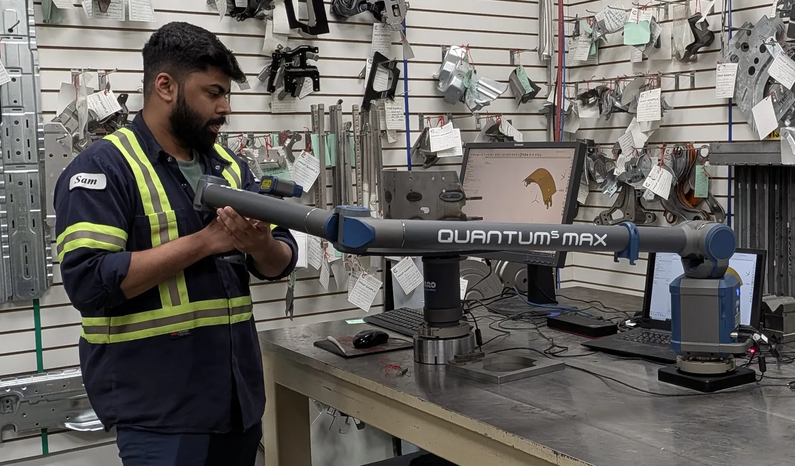A Clover inspector using a portable CMM scanning arm at the layout table, dimensional data on screen.