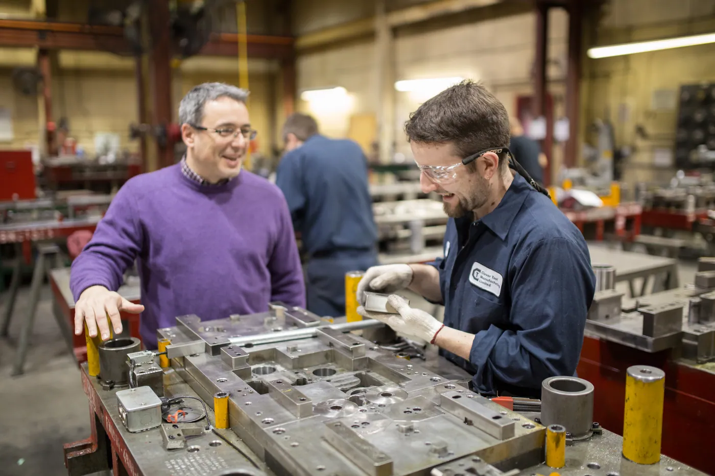 Tool & die makers collaborating over a progressive die at Clover’s in-house tool room.