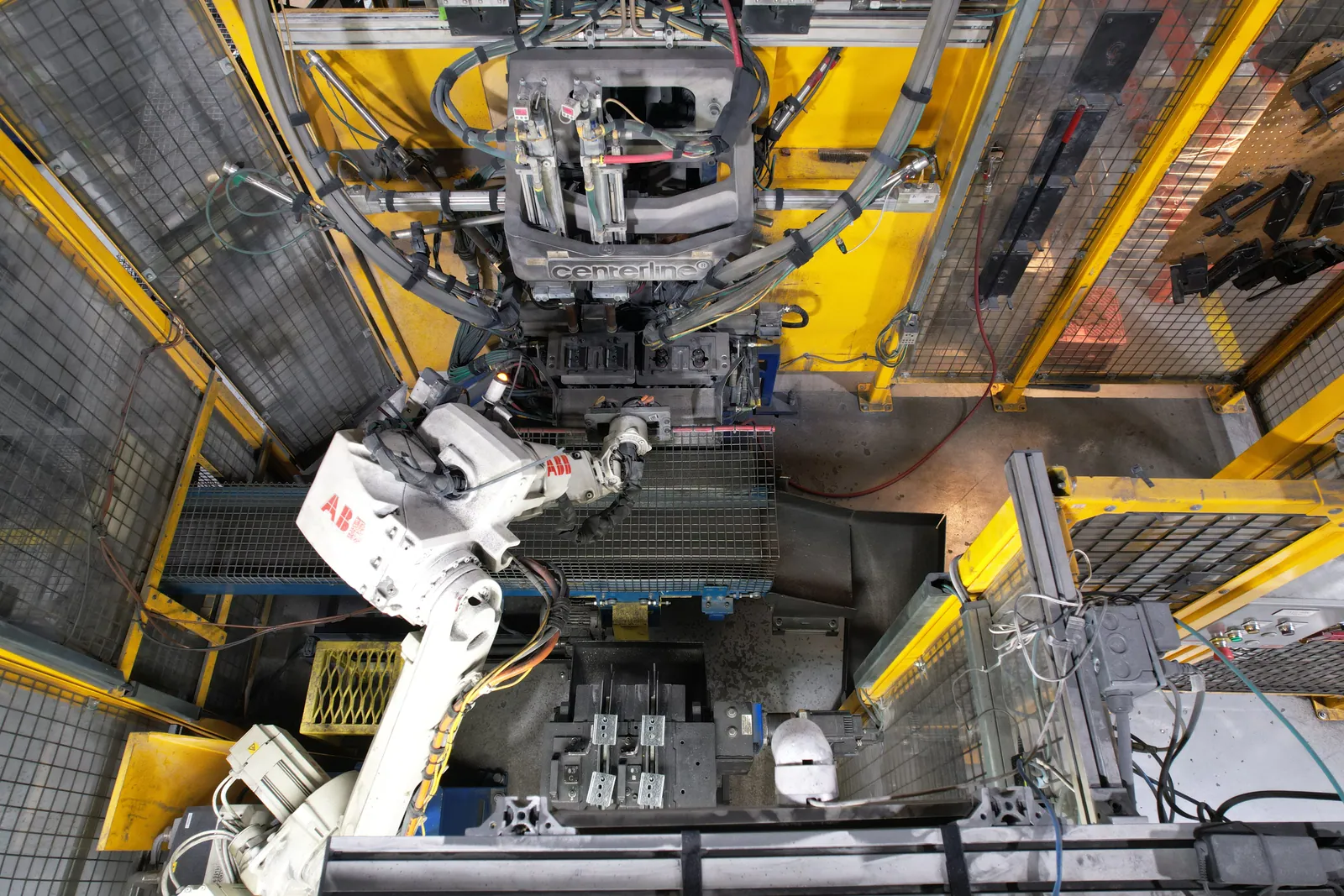 Robotic welding cell with ABB arm running production.